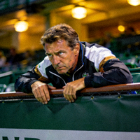 网球教练在看台上为弟子加油的专注神情